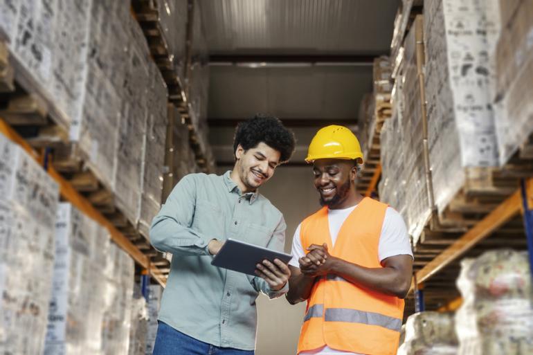 Dos hombres revisando un inventario en bodega